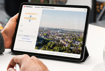 Laptop mit Wiesbadener Logo und Blick von oben auf die Stadt